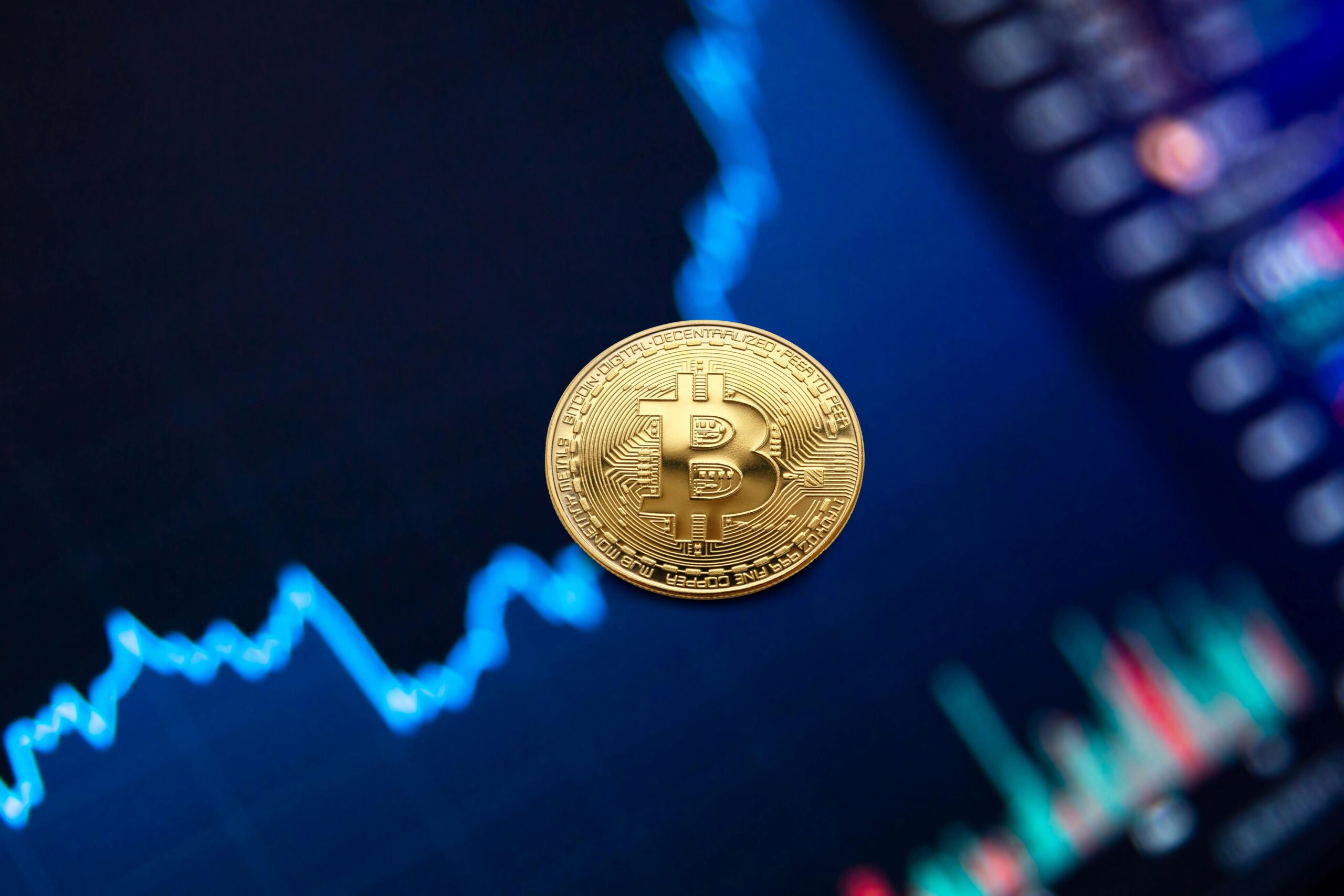 Physical Bitcoin token on top of a screen.